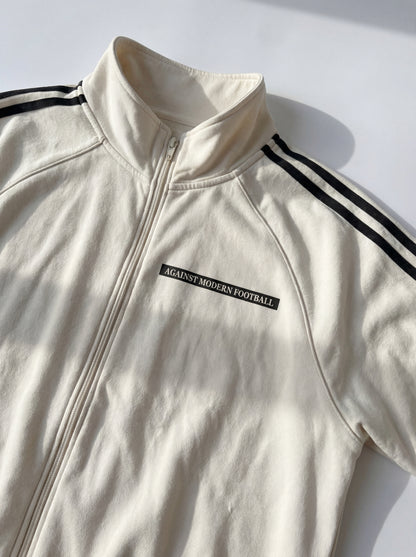 AGAINST MODERN FOOTBALL - CHAQUETA CON CREMALLERA Y DETALLES REFLECTANTES